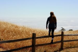 woman jump on brown fence